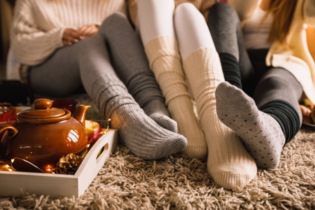 a trio of legs bundled up on a fuzzy carpet, enjoying healthy Indoor Air Quality in Winter